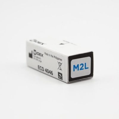 A small white box labeled M2L on one end with ECO 4046 and Made in the Philippines on the side, likely packaging for an Easywear wired RIC (M-Receiver), is placed on a plain white surface.