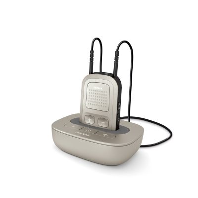 The Phonak TV-link II package (ComPilot II + Base II) includes a compact device with gray accents, plus and minus buttons, speaker, and two black cords, resting on a charging dock.